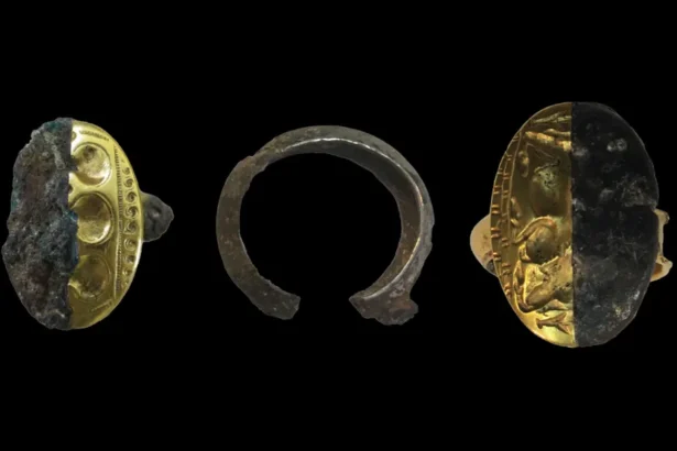 Three archaeological artifacts on a black background: a gold ring with decorative band partly encrusted in dark material, a rusted metal ring fragment in the center, and a gold coin half-buried in dark crust on the right.