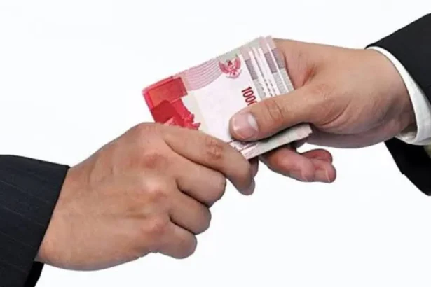 Two hands exchanging a stack of 100,000 Indonesian rupiah banknotes in a cash handoff.