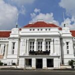 Front facade of the Bank Indonesia Museum: a white, neoclassical building with red-tiled roof and columns on a city street.
