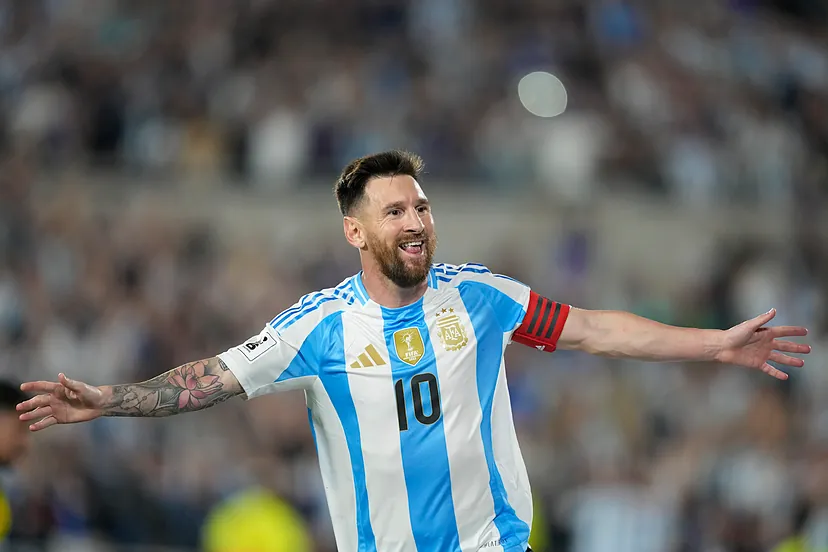 17665865486134 - Mabur.co Argentinian soccer captain in a blue-and-white jersey with number 10 celebrates with arms outstretched on the pitch.