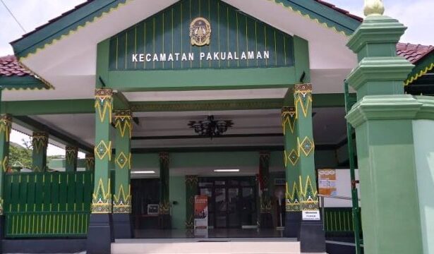 Front entrance of the Kecamatan Pakualaman government building, with green and yellow decorative columns and a sign above the doorway nose.