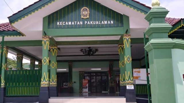 Front entrance of the Kecamatan Pakualaman government building, with green and yellow decorative columns and a sign above the doorway nose.