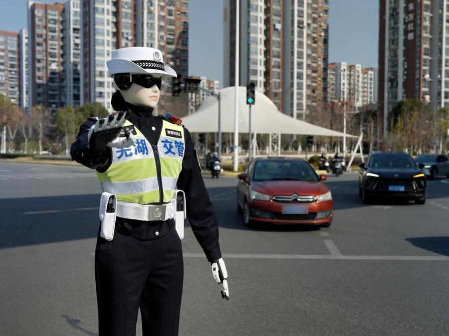 Traffic police officer in a reflective vest directing traffic at a busy urban intersection with tall buildings in the background.