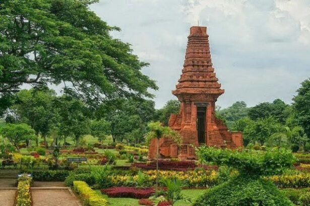Red brick, pagoda-like temple in a manicured garden with pathways and trees surrounding it.