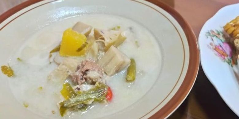 Creamy white soup in a bowl with pork chunks, yellow bell pepper, and mixed vegetables