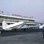 Vintage propeller airplanes parked on the tarmac in front of Kemayoran International Airport terminal building.