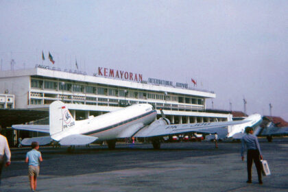 Vintage propeller airplanes parked on the tarmac in front of Kemayoran International Airport terminal building.