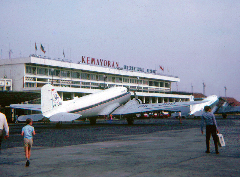 Vintage propeller airplanes parked on the tarmac in front of Kemayoran International Airport terminal building.