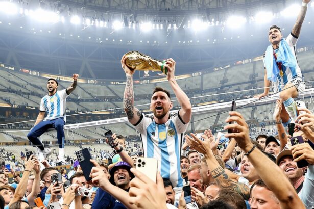 Soccer players celebrate a championship, lifting a golden trophy above a cheering crowd in a stadium.