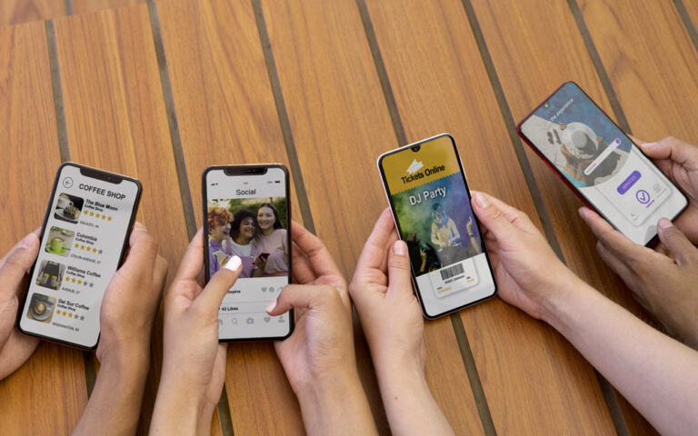 Five hands hold smartphones over a wooden table, displaying a cafe menu, social feed, a DJ party ticket, and a music app interface. Includes café, social, tickets, and music contexts in one scene.