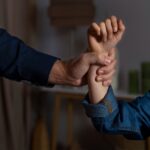 Two people hold each other’s wrists in a firm grip, close-up on their hands against a blurred background.