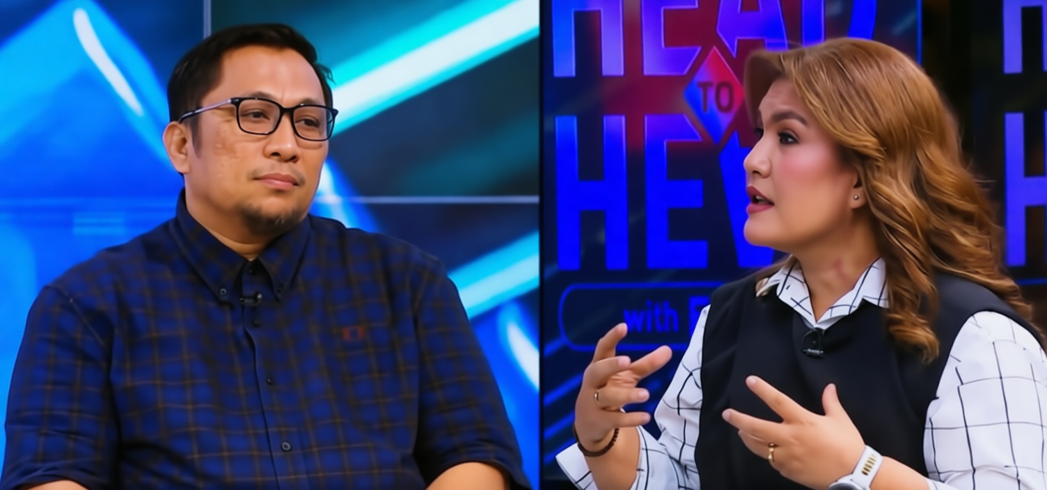 Two TV hosts on a talk-show set; man with glasses in a blue plaid shirt on the left and a woman in a white checkered blouse with a black vest on the right, gesturing as they talk.