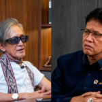 Two men sit across from each other in a split-screen setup: an older man with sunglasses and a patterned scarf on the left, and a man in a dark blue shirt on the right.