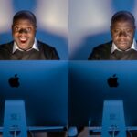 Two men sit side by side at blue Apple computer monitors; left man smiles broadly, right man looks down in a somber mood.