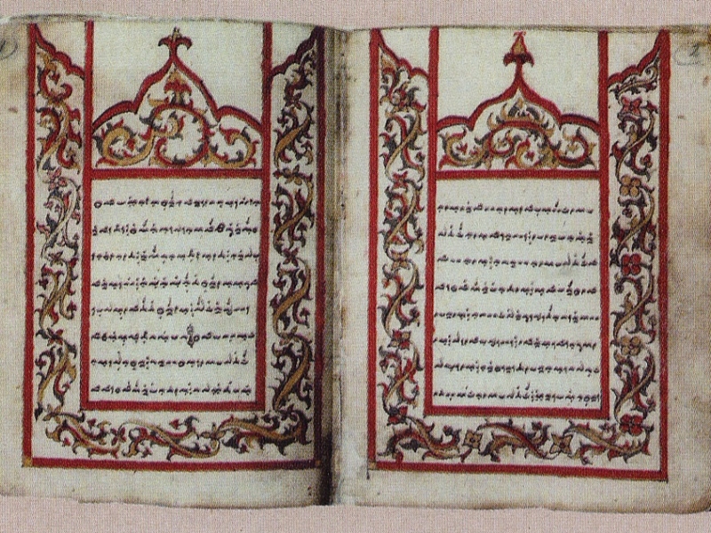 Foto Literasiliwangijpg - Mabur.co Two-page illuminated manuscript with ornate red and gold floral borders surrounding dense blocks of handwritten text.