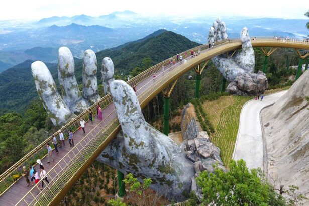 Pedestrian walkway held by giant stone hands, curving over a valley with travelers along a golden bridge.