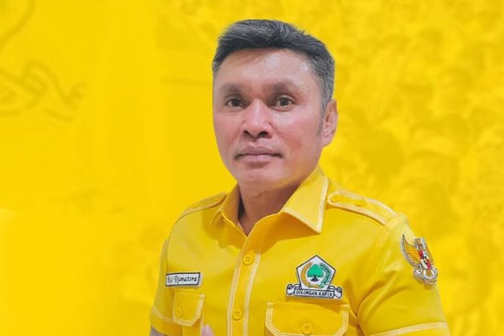 Portrait of a man in a bright yellow uniform with patches, standing against a solid yellow backdrop.