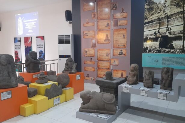 Display of various stone statues and carvings arranged on orange and yellow pedestals in a museum gallery, with informational plaques nearby.
