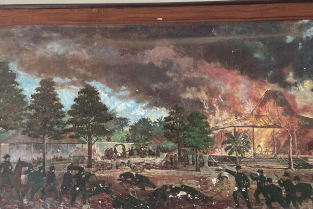 Battle scene in a tropical garden: soldiers fire, people flee, and a thatched pavilion burns in the background.