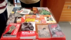 Table with a red cloth displaying many political and historical magazines and books in Indonesian.