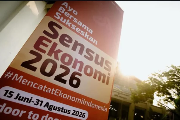 Tilted orange banner announcing 'Sensus Ekonomi 2026' with dates and hashtag #MencatatEkonomiIndonesia, sunlit outdoor setting.