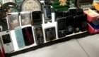 Shelf displaying vintage mobile phones (Nokia, Sony Ericsson) and iPods lined up for sale.