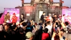Crowd watches a racing event on a marble stage with banners reading Pertamina Grand Prix of Indonesia 2016; speakers and camera phones abound.