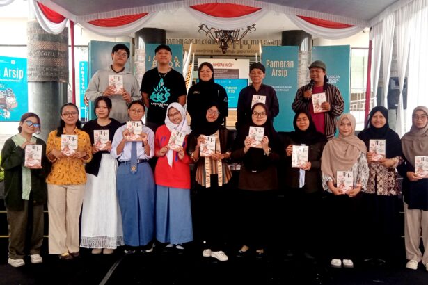 Group of students and organizers on a stage at a book fair, each holding a booklet or program.