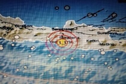Weather radar map showing a storm near a coastal island, with a red circular target around a yellow center marker and labeled towns nearby.