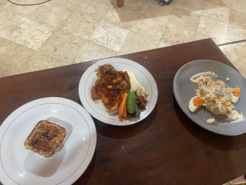 White plate with glazed chicken, mashed potatoes, and carrot and green bean sides on a wooden table.