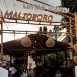 Entrance to a market stall with bamboo frame and hanging woven lanterns.