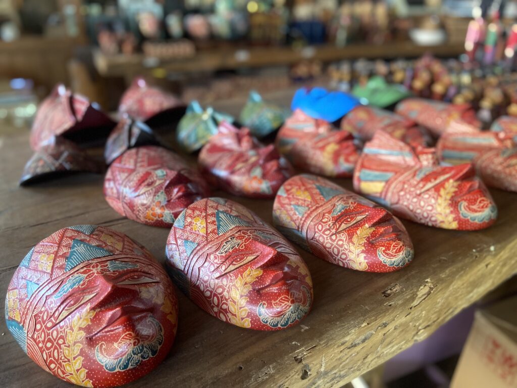 IMG_7395 - Mabur.co Colorful patterned fabric wraps laid out on a wooden shelf in a shop