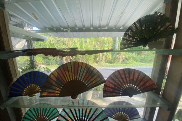 Colorful fold-out paper fans arranged along a windowsill with greenery outside.