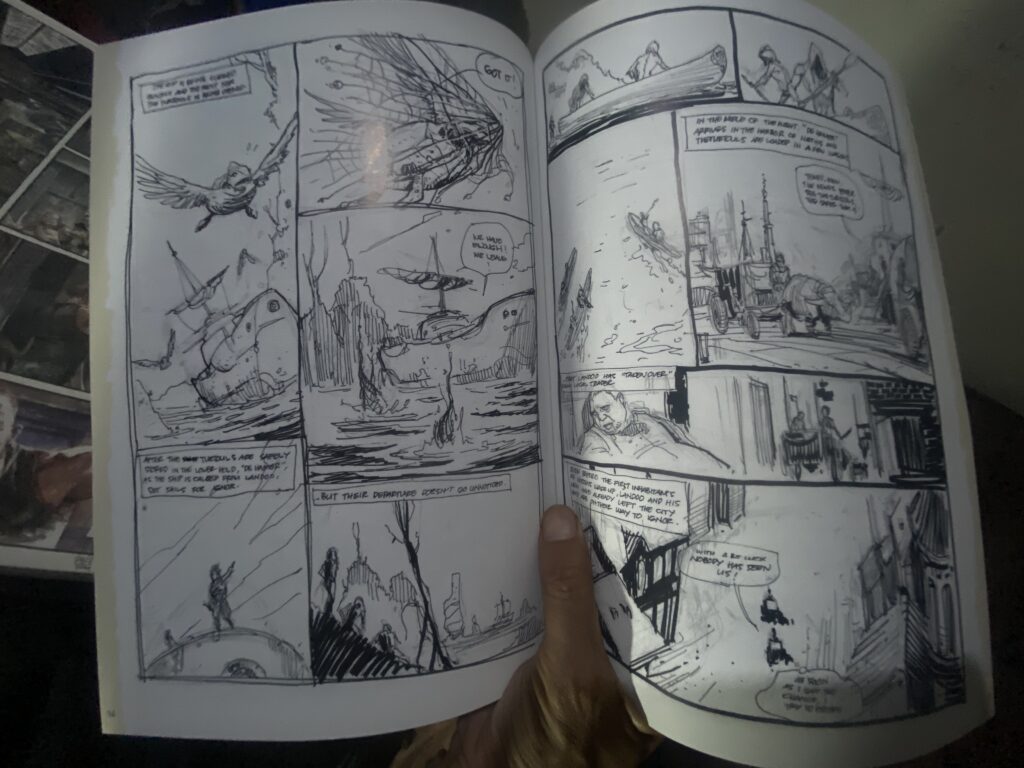 Open two-page comic spread with hand visible, featuring black-and-white ink panels and speech bubbles.