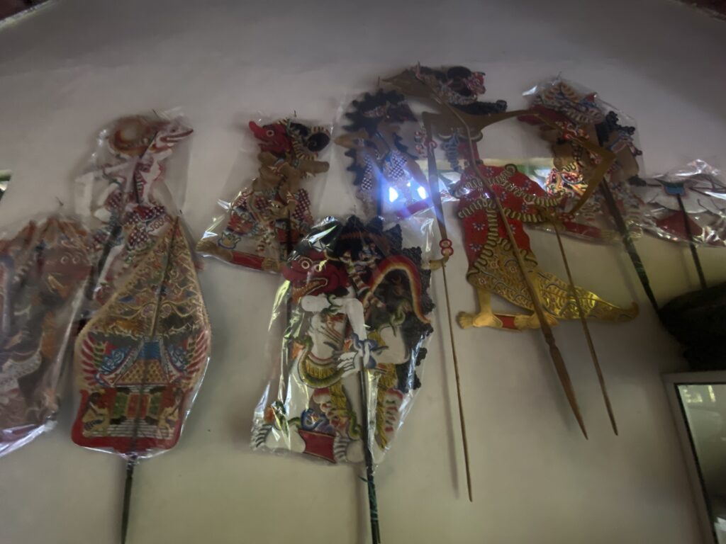 Colorful Chinese dragon-themed decorations hanging indoors, wrapped in plastic bags against a light wall.