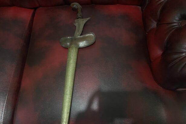 Antique curved dagger with ornate handle lying on a red leather sofa.