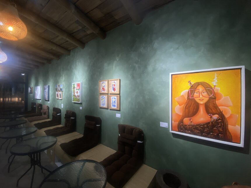 Gallery interior with green textured wall, wooden ceiling beams, and a large orange portrait on the right.