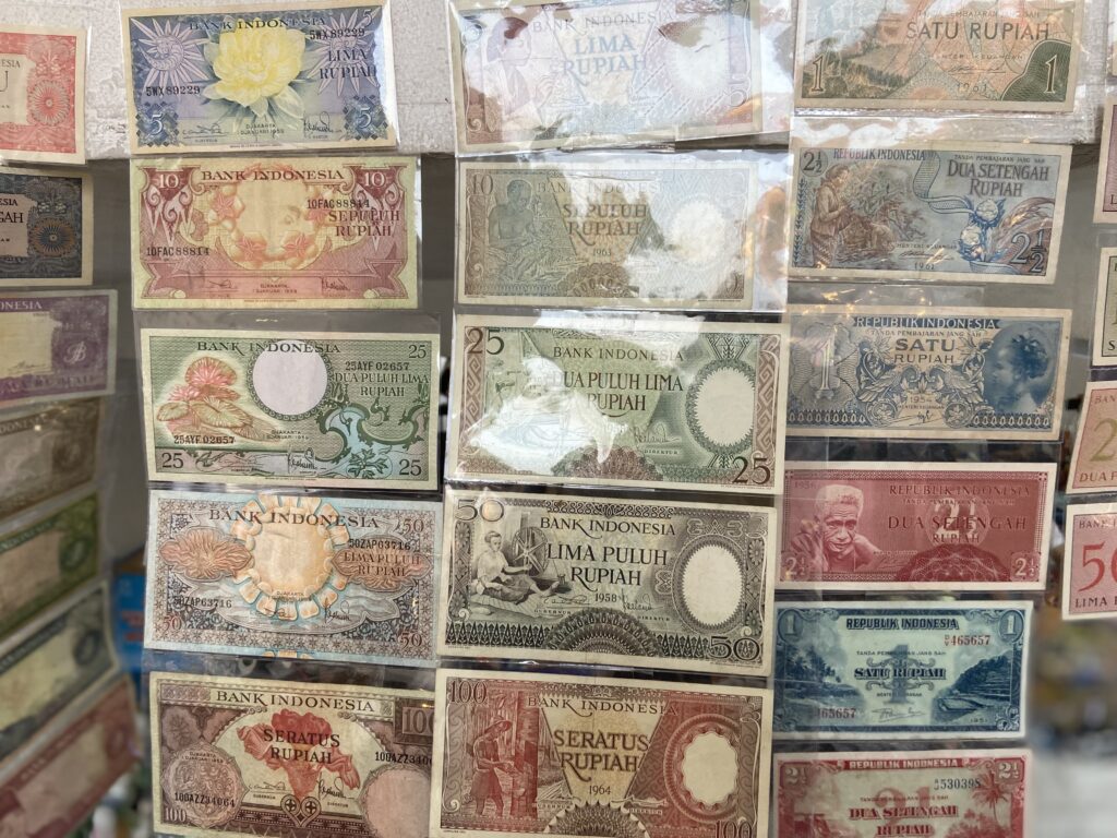 Display of vintage Indonesian banknotes in a grid arrangement showing various denominations and designs.