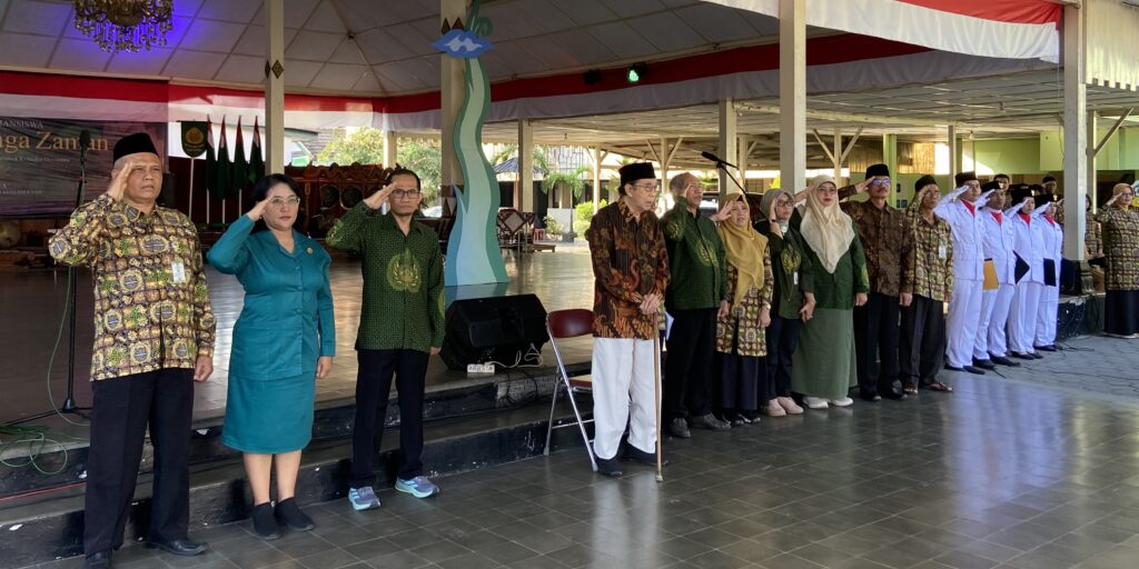 IMG_9727 - Mabur.co Group of officials and participants standing in a line and saluting during a formal ceremony under a red-and-white decorated canopy.