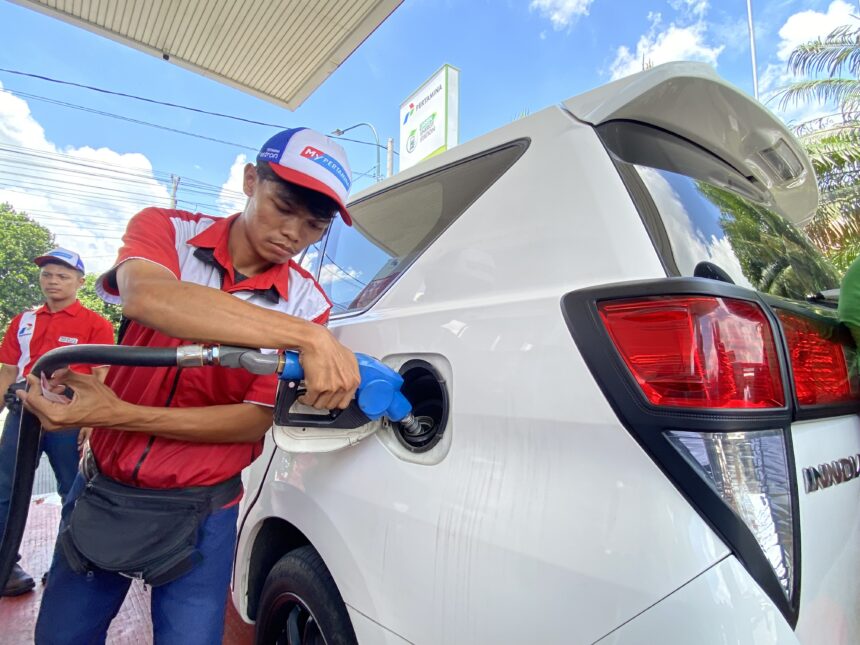 IMG_9999 - Mabur.co Gas station attendant in red uniform refueling a white van at the pump with a blue nozzle.