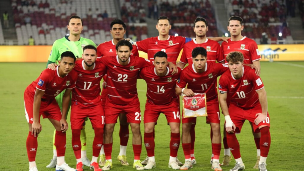 Indonesia pose vs Bulgaria by detikfoto FIXX - Mabur.co Soccer team in red jerseys posing for a pre-match photo on the field, one player holds a pennant.