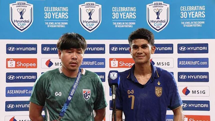 Two football players answer questions at a press conference, backdrop filled with Hyundai and ASEAN logos; one in green jersey with lanyard, the other in blue with number 7 smile behind a microphone.