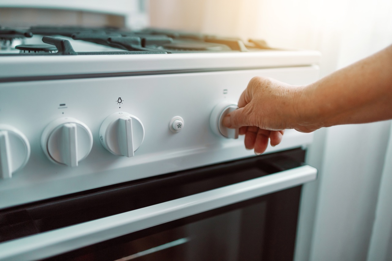 Woman hand regulates the temperature of new gas stove - Mabur.co