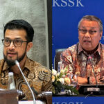 Two men in batik shirts speaking at a panel, each at a separate podium with microphones.