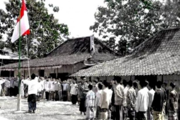 Crowd of villagers standing in a line during a flag-raising ceremony in a rural courtyard with traditional tiled-roof houses nearby.”] ,