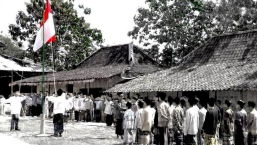 Crowd of villagers standing in a line during a flag-raising ceremony in a rural courtyard with traditional tiled-roof houses nearby.”] ,