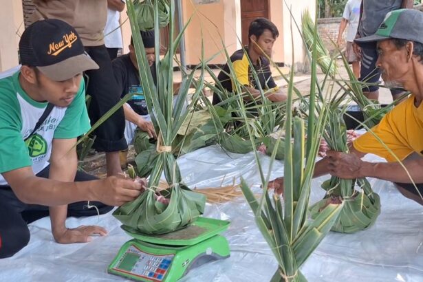 Group of men kneeling on a plastic sheet, weaving pandan leaves into small round baskets for sale or ceremony on a workshop day