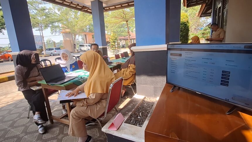 Screenshot_20260622_205556_Gallery - Mabur.co Group of people in hijabs seated at a table with a laptop and documents outside, engaging in a service or registration session at a booth.