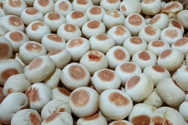 Pile of small white steamed buns with light brown tops in a basket.