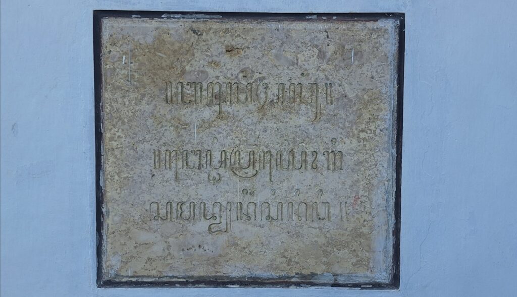 Screenshot_20260715_095155_Gallery - Mabur.co Weathered stone plaque with faded Armenian inscription mounted on a blue wall.